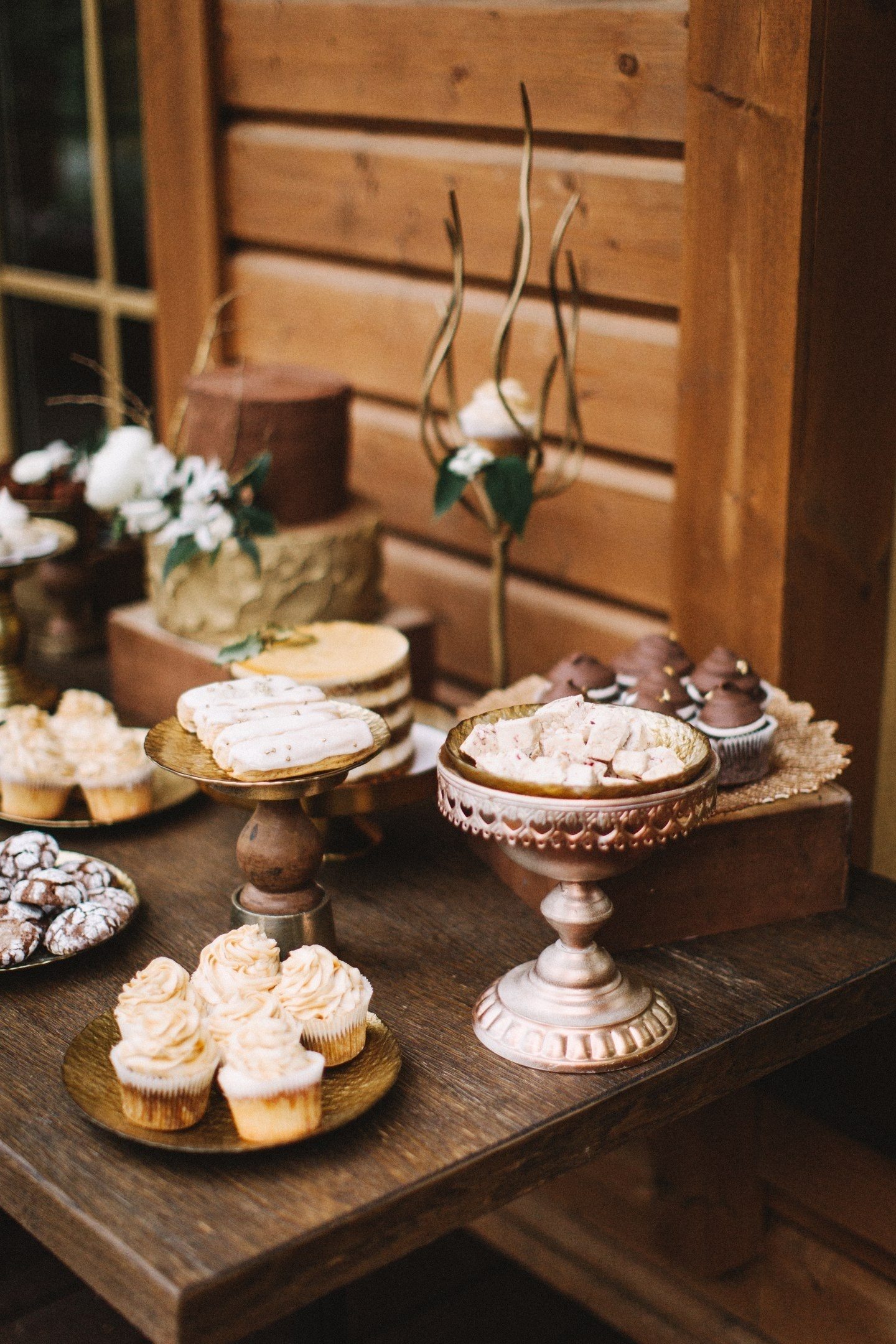 Brutna barer med choklad, tryffel, mjuka luftiga efterrätter, dekorerad med kaffebönor och openwork-kakor med isbildning i bröllopsstil, ser bra ut i sällskap med åldrade lådor och utsmyckade ställen